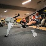 man traint in een fitness op een roeiapparaat- had enorme last van knieklachten