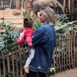 vrouw met kindje op de arm in de dierentuin