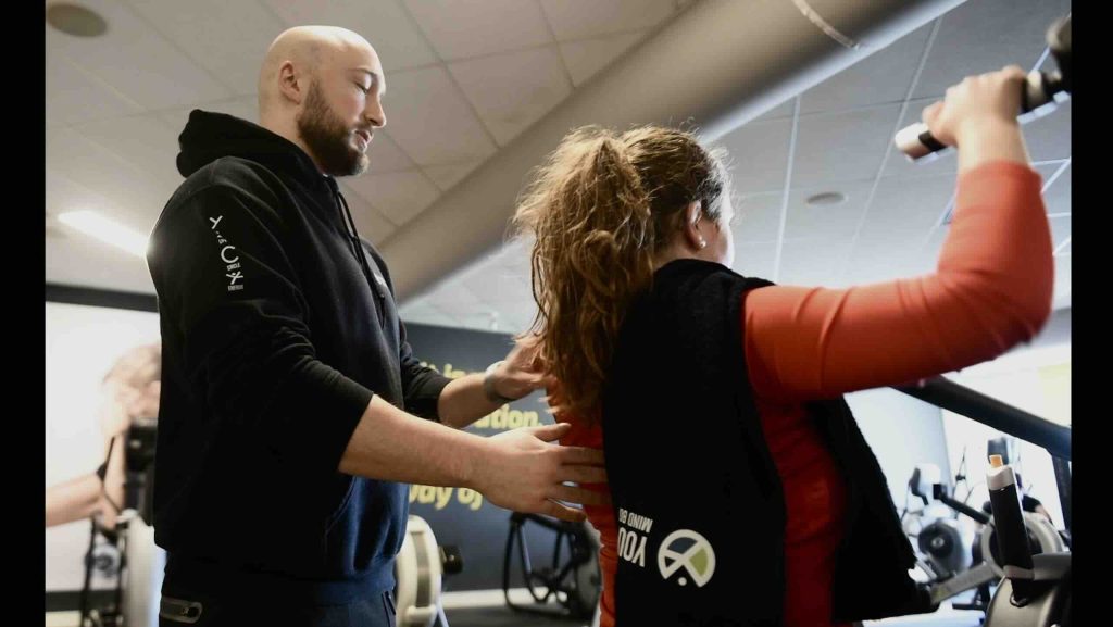 Personal trainer begeleid jonge dame