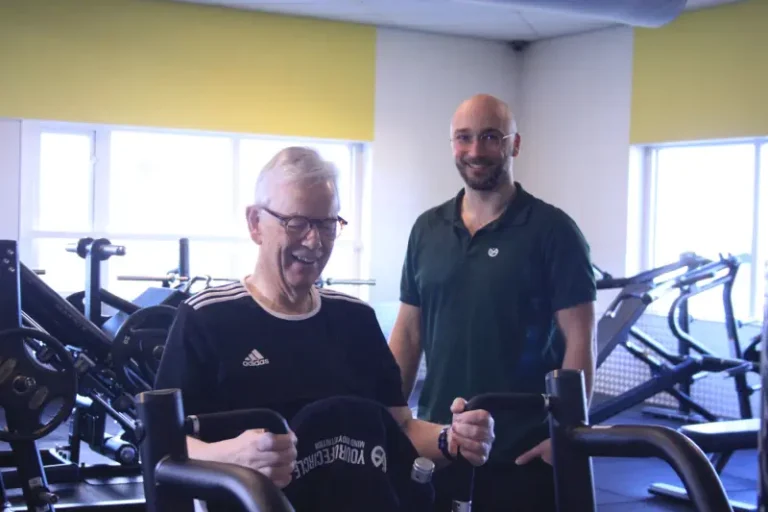 enthousiaste oudere heer traint onder leiding van personal trainer Jeroen bij Yourlifecircle