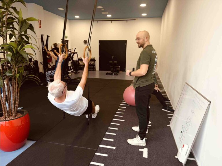 Jeroen coachend in de groepsles met volle groep die oefeningen doen.