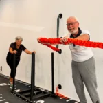 koppel samen aan het sporten. vrouw duwt de slee en man duwt touw naar voren