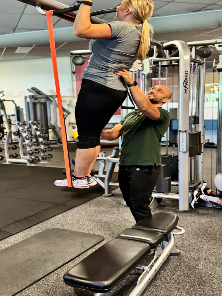 Moeder doet een begeleide pull up met personal trainer Jeroen