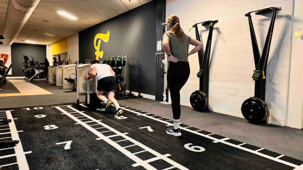Koppel doet sled push oefening van gymrace